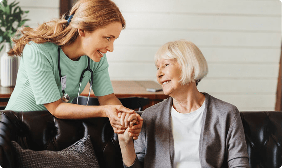 Eine Betreuungskraft im Gespräch mit einer Seniorin zu Hause